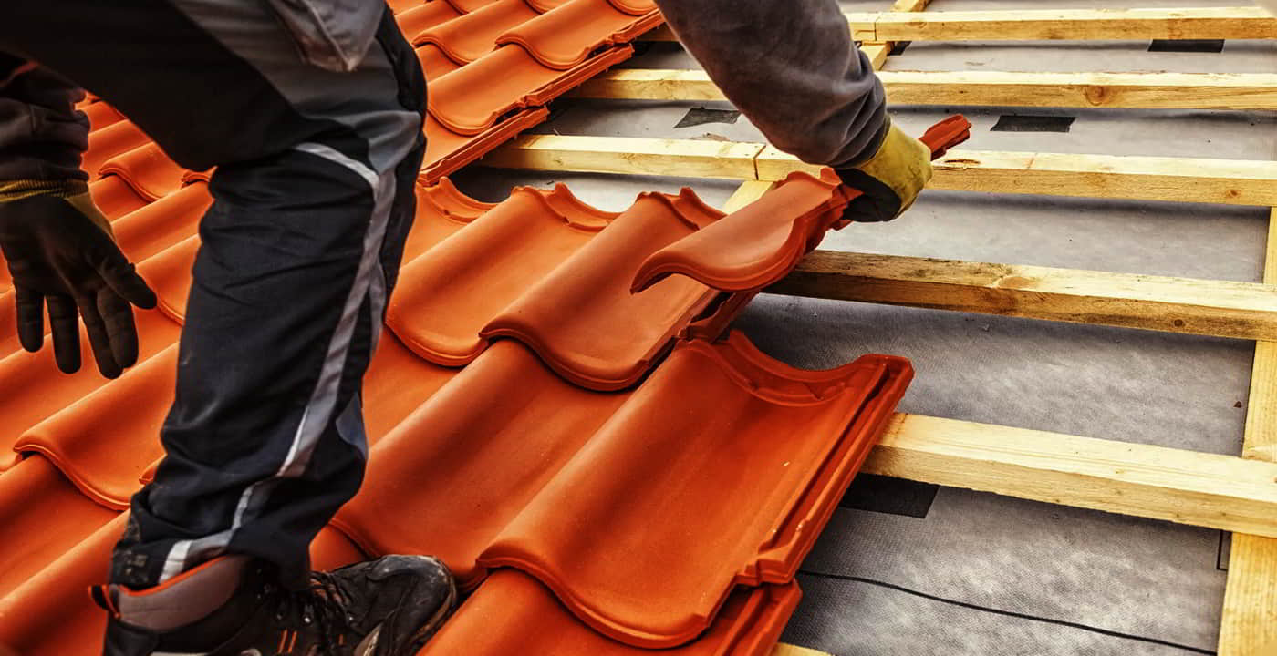 man placing a tile roof